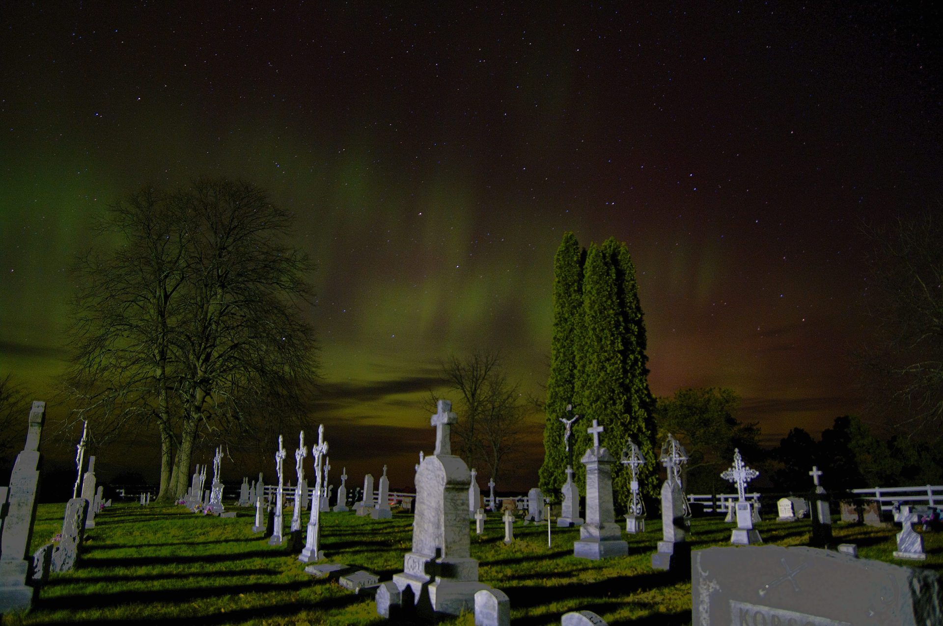 Northern Lights aka Aurora Borealis shining bright over graveyard in the Leelanau Peninsula of Michigan