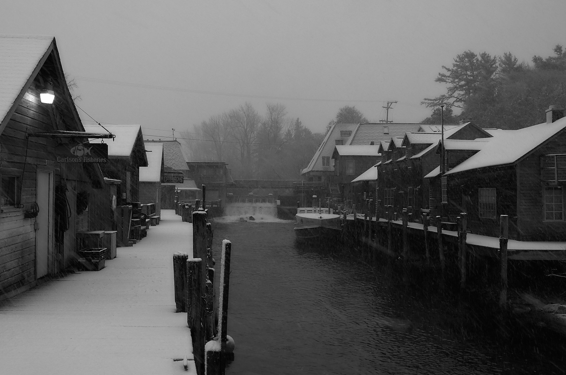 Carlsons fish market in winter looking upriver towards the dam in the shanty village of fishtown Leland Michigan