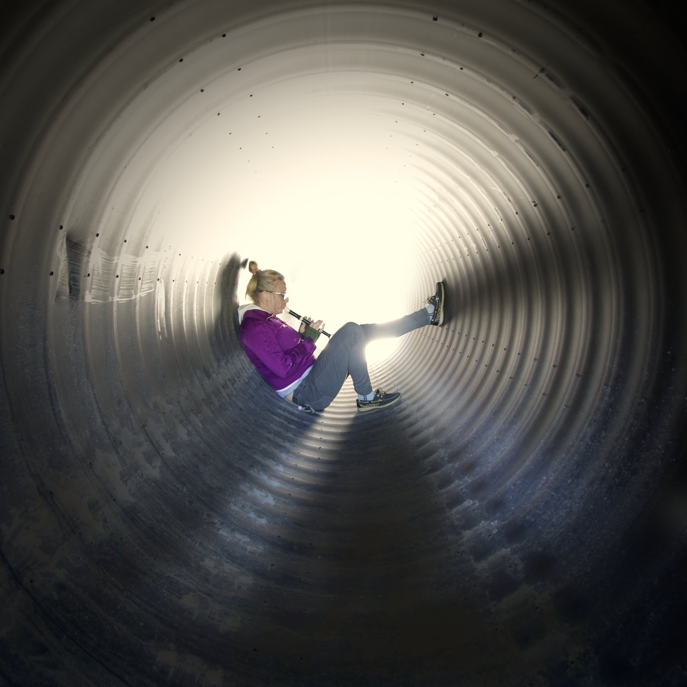 woman playing recorder in a backlit tunnel at Suttons Bay Michigan
