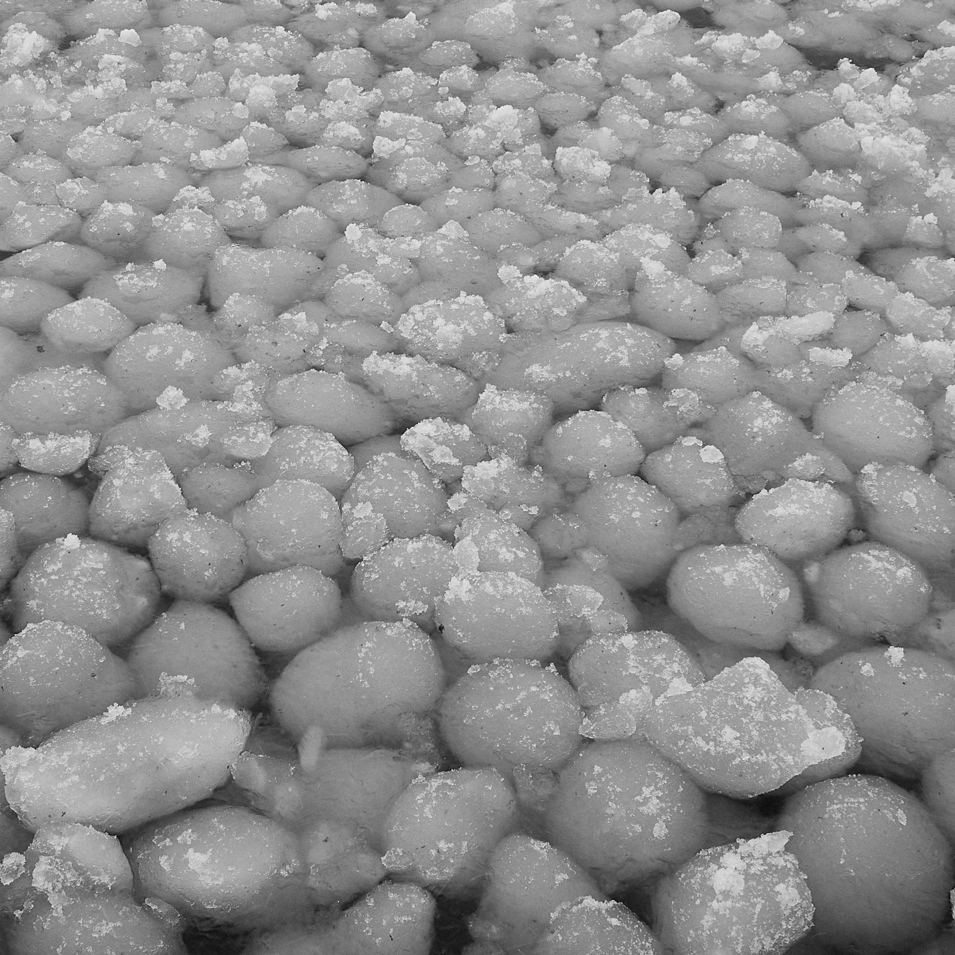 ice balls packed shore ice against ice caves at vans beach in Leland Michigan