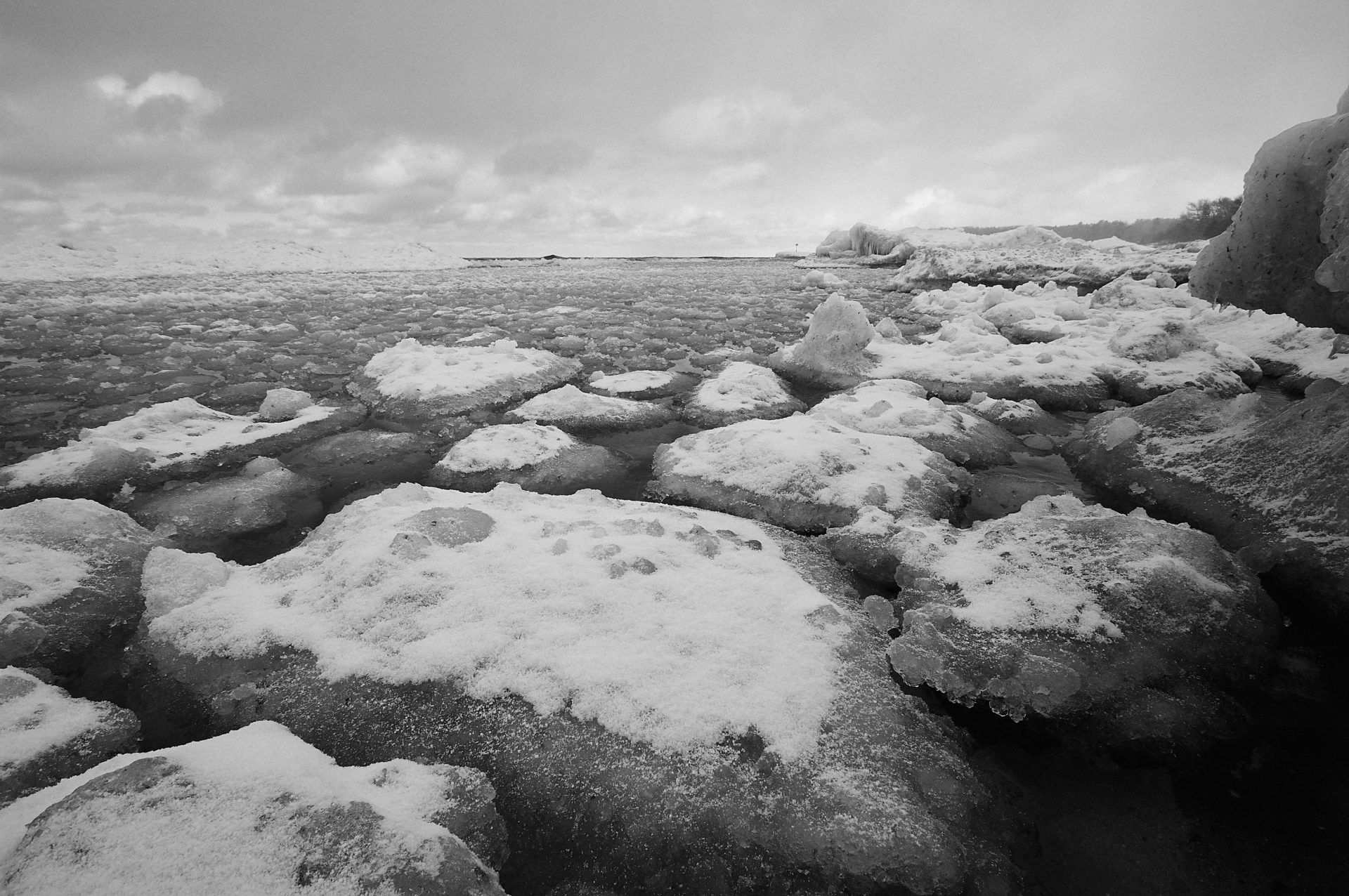 looking north towards Leland harbor with packed shore ice against ice caves at vans beach in Leland Michigan