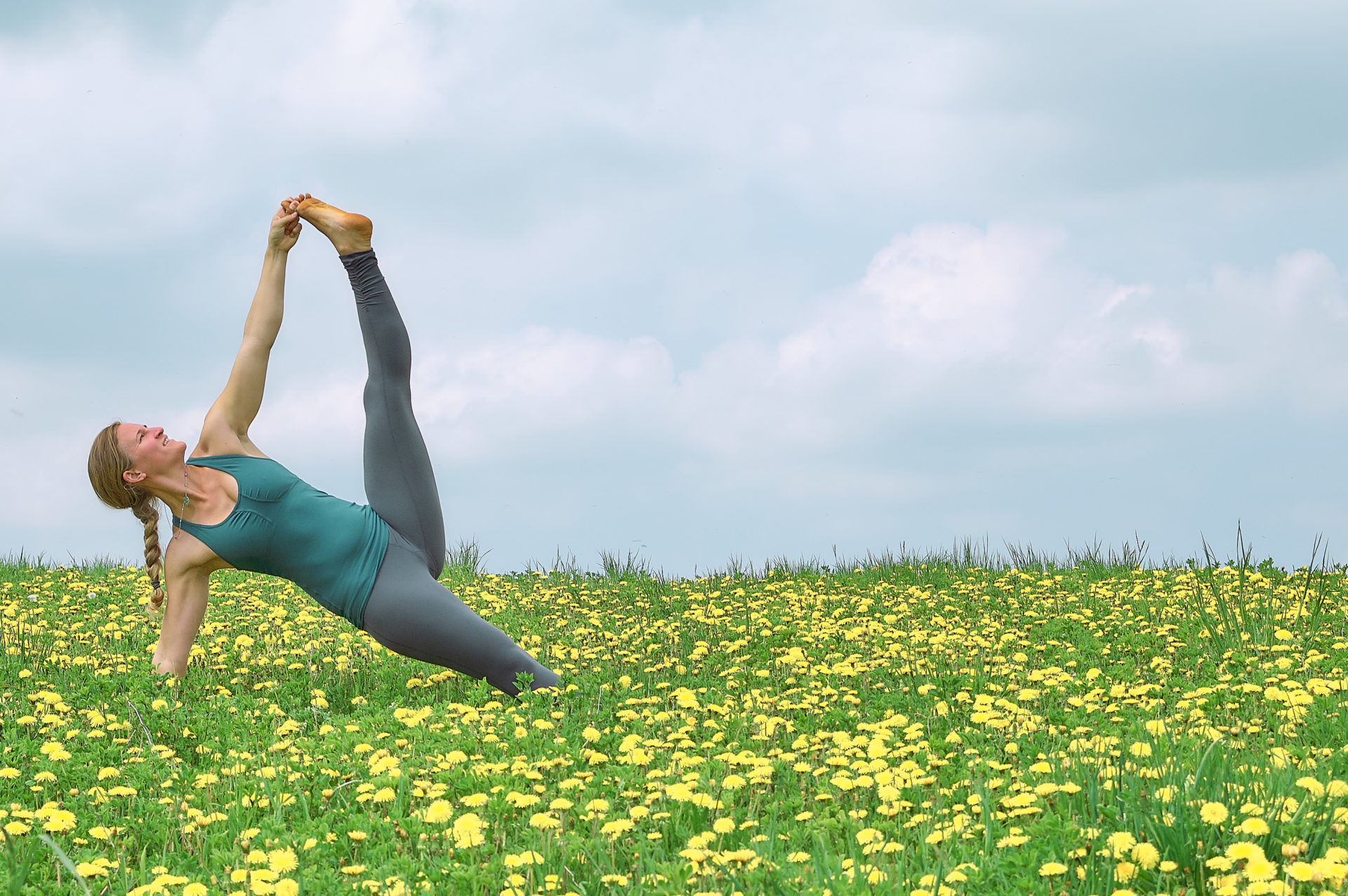 woman practicing yoga in open field of yellow dandelion flowers at Suttons Bay Michigan