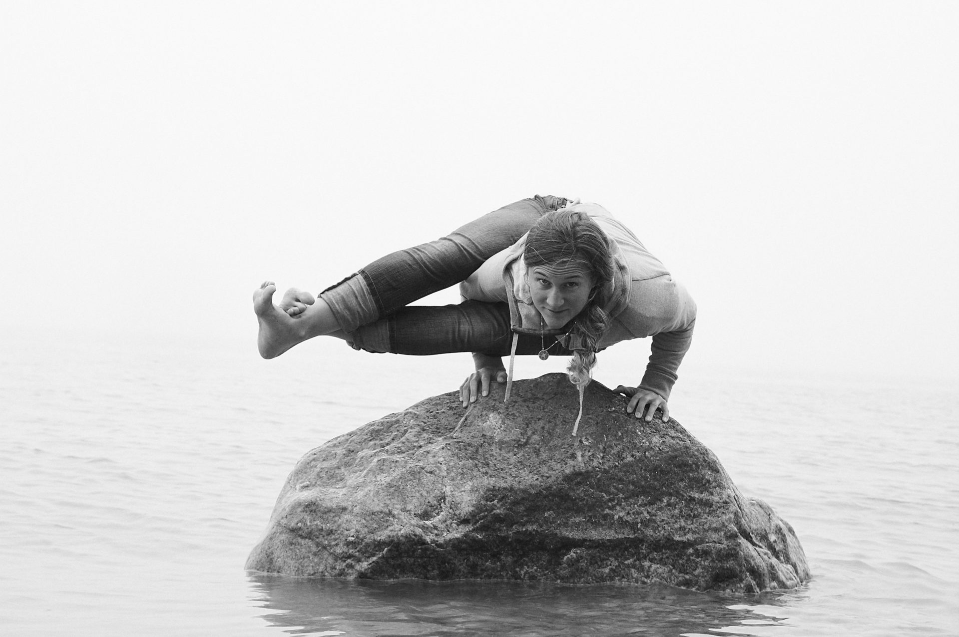 woman practicing yoga on a rock in Lake Michigan