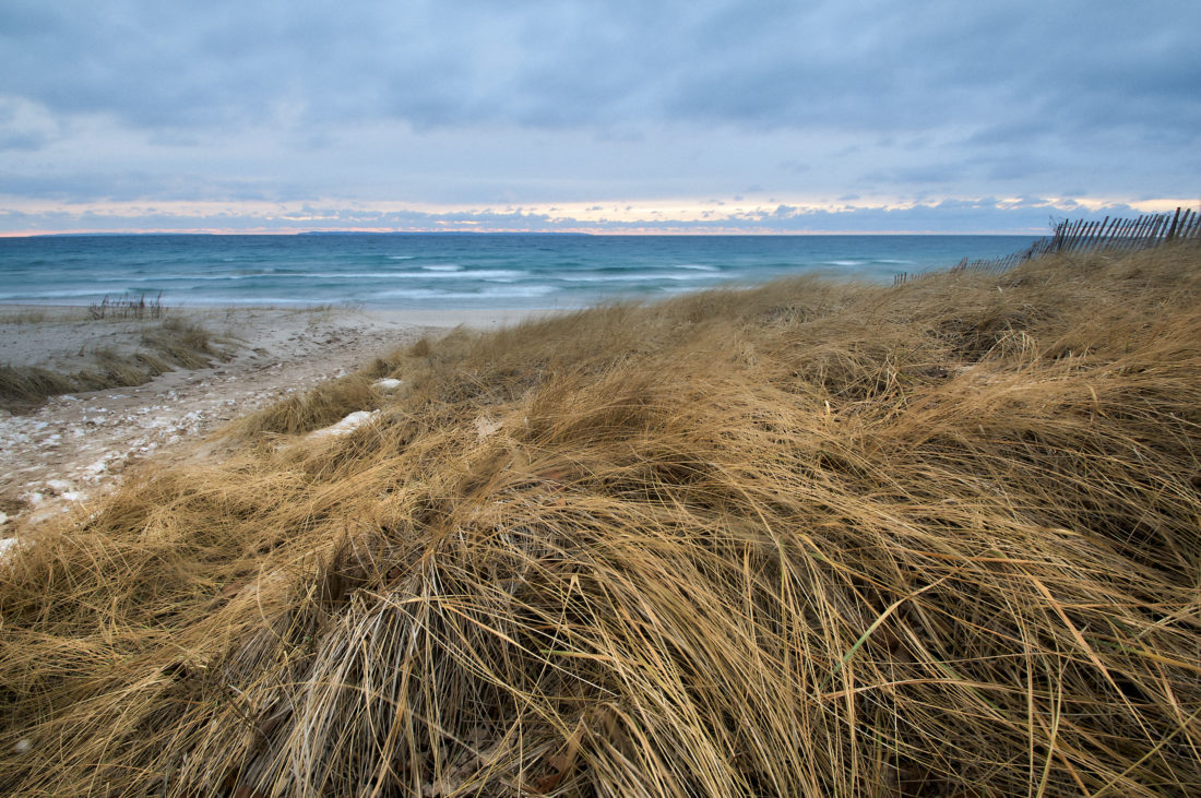 beach scene looking at Lake Michigan over dune grass on a stormy day