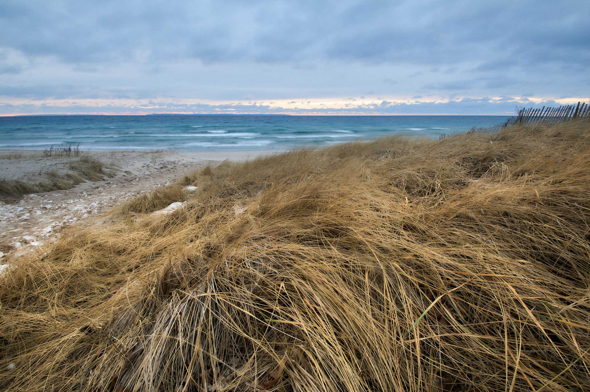 beach scene looking at Lake Michigan over dune grass on a stormy day
